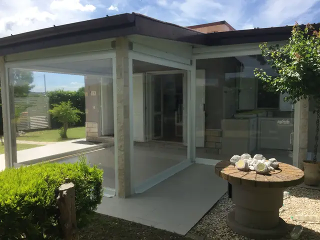 Veranda chiusa con vetrate e struttura in alluminio realizzata da Artex Tende
